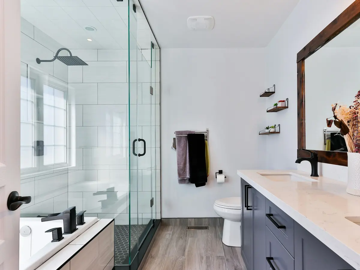 A finished bathroom remodel with a tiled walk-in shower and new vanity